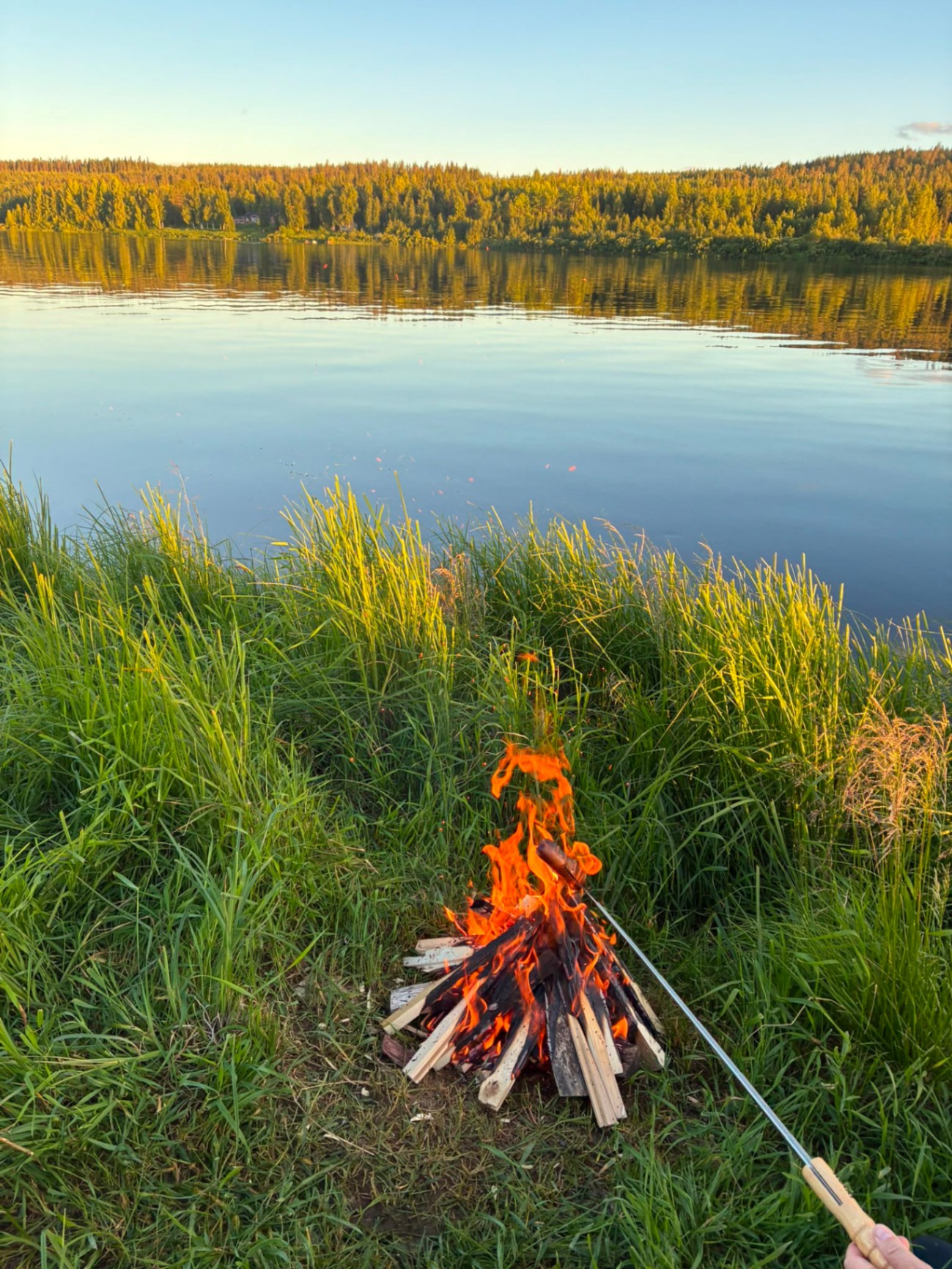 Nuotio Ounasjoen rannalla keskiyön auringon alla